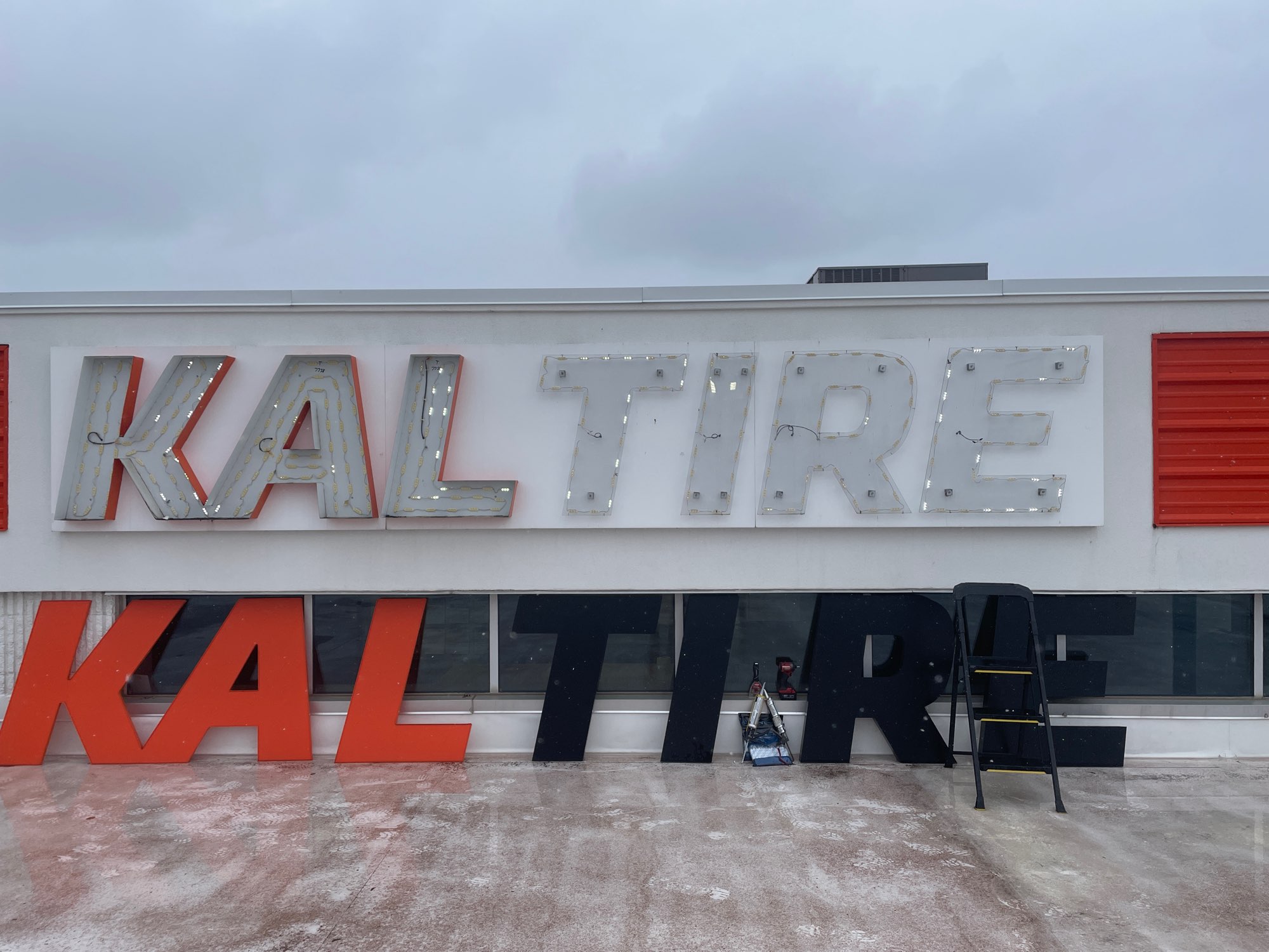 the internal parts of large outdoor sign that is red and back letters for Kal Tire