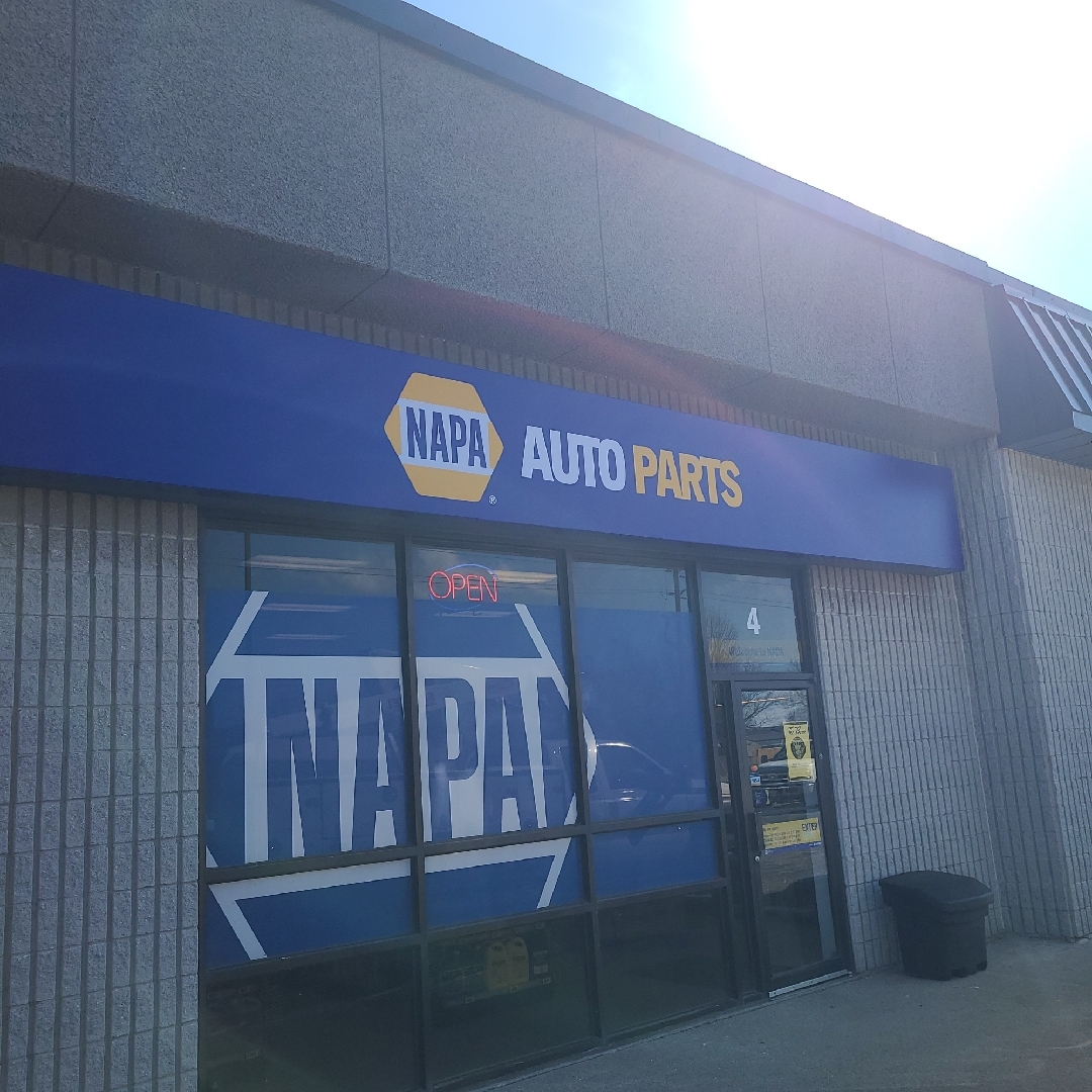 a blue and yellow napa auto parts sign over the front door of the business