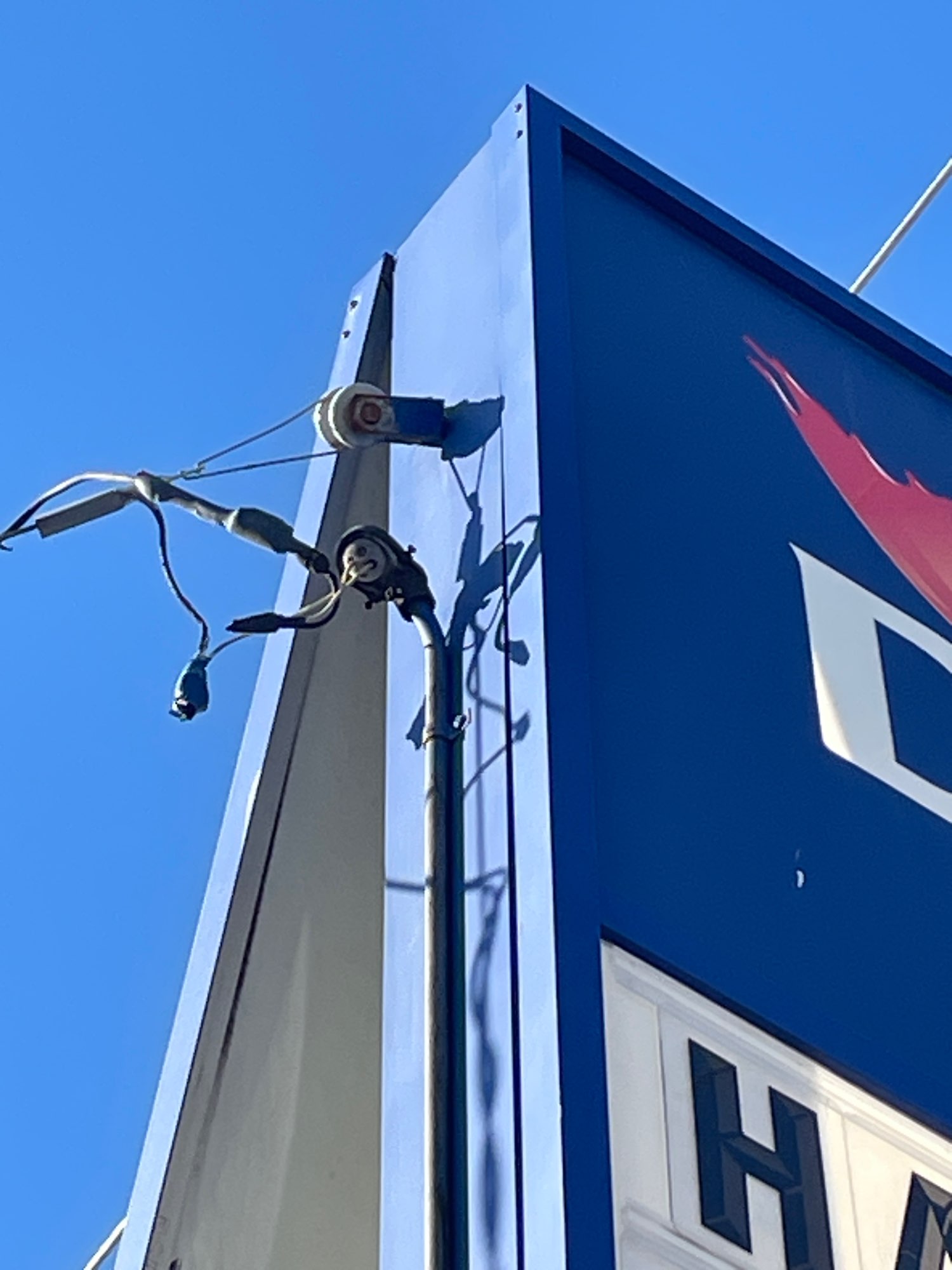 a large blue and red and white sign with wires coming off the side