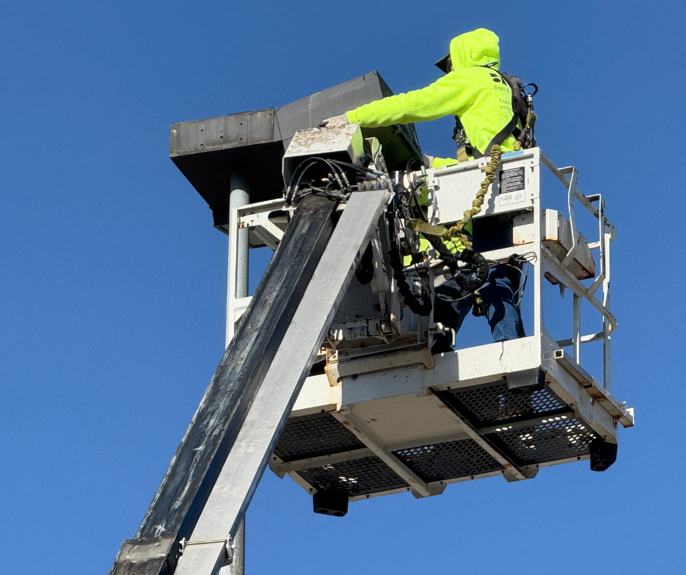 yesco employee fixing parking lot light